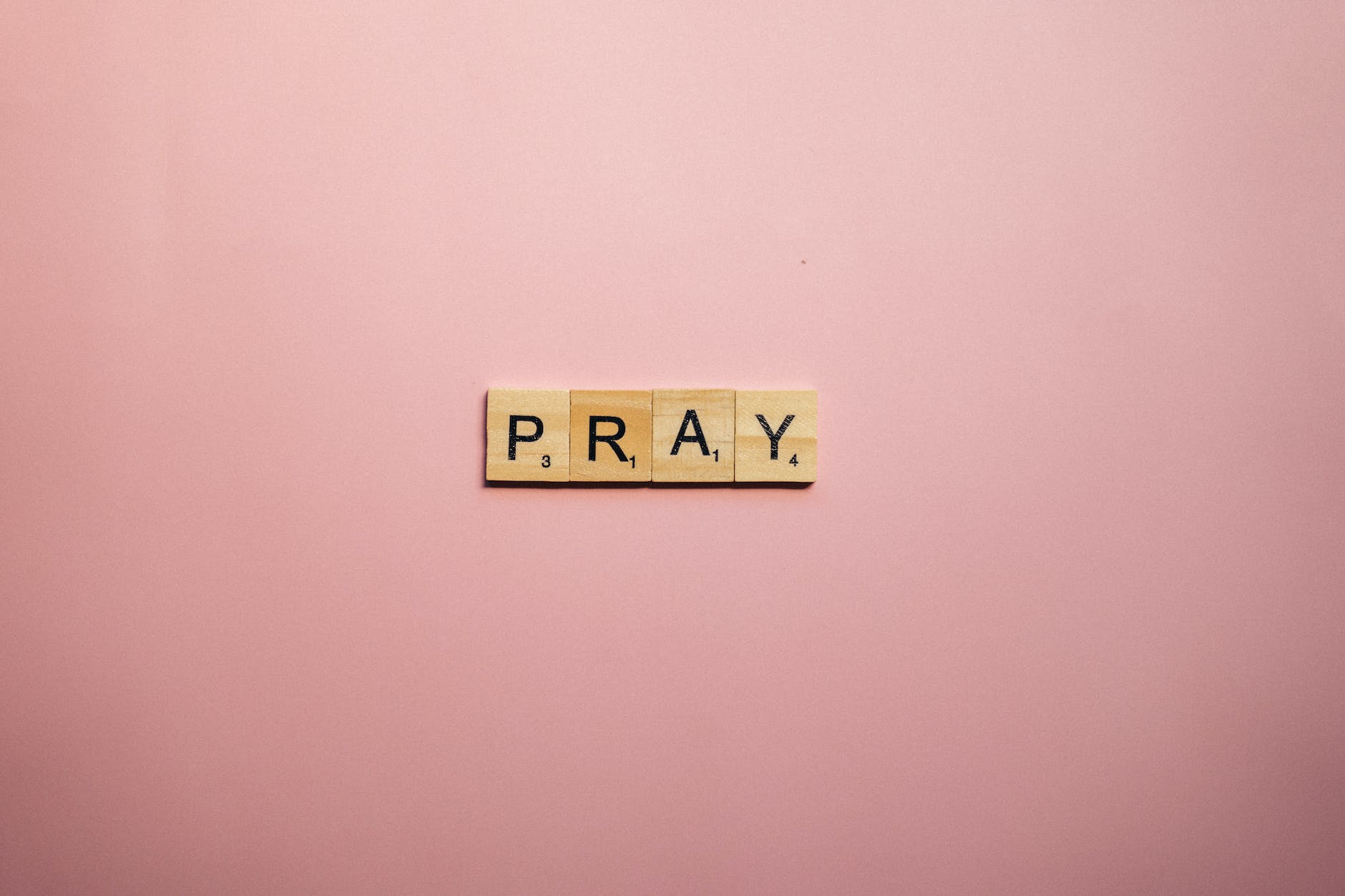 scrabble tiles on pink surface